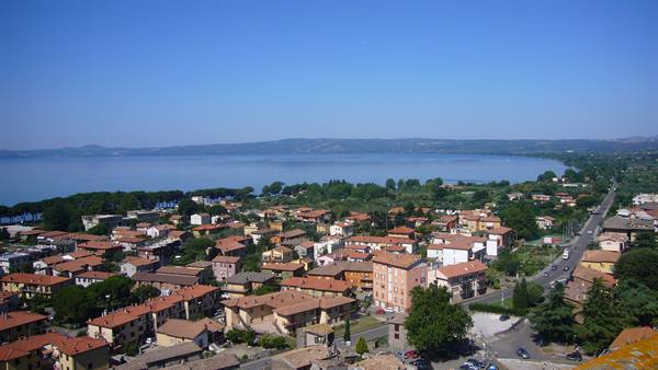 Red rooftops of Castiglione del Lago facing the blue Lake Trasimeno
