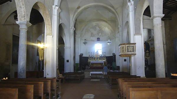 Church interior with stone columns, wooden pews and altar lit by window