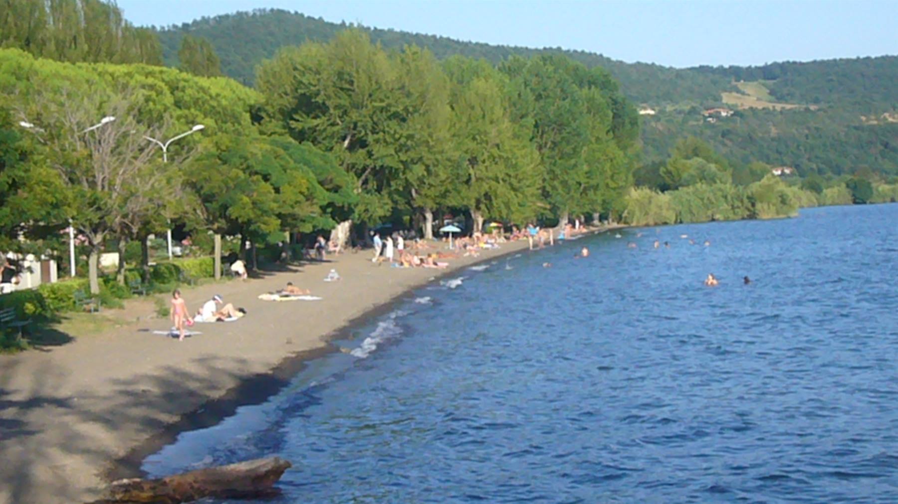 Spiaggia sabbiosa al Lago di Bolsena, bagnanti sull'arenile e nuotatori nell'acqua