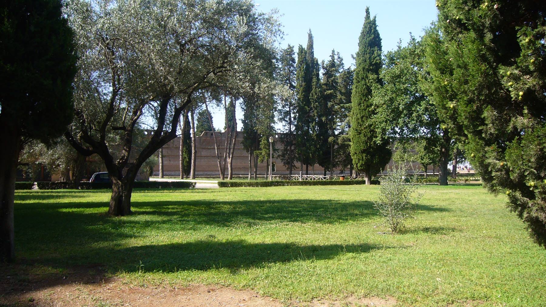 Giardino con ulivi e cipressi davanti alle antiche mura di Roma