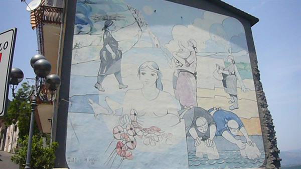 Mural on building wall: women washing clothes and walking, daylight