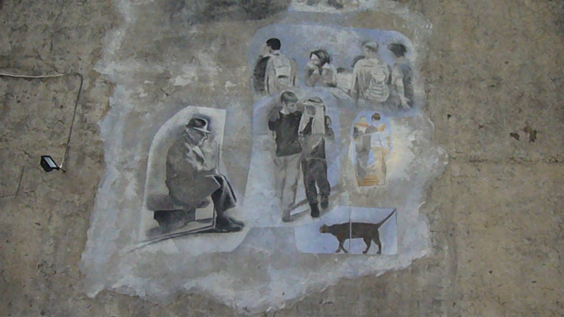 Murale su muro di cemento: anziano seduto con cappello, passanti e gatto nero