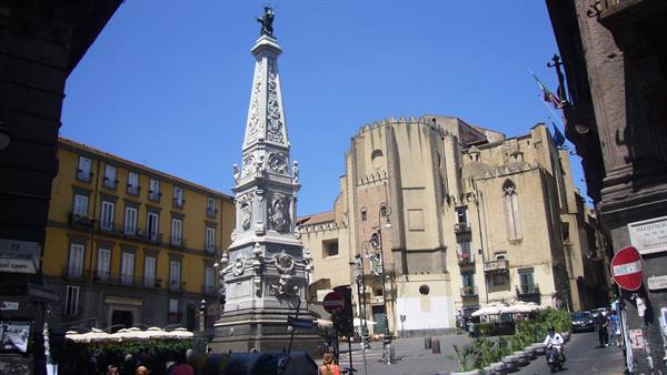 The marble Obelisk of the Immaculate Virgin in Piazza del Gesù Nuovo, Naples, under blue sky