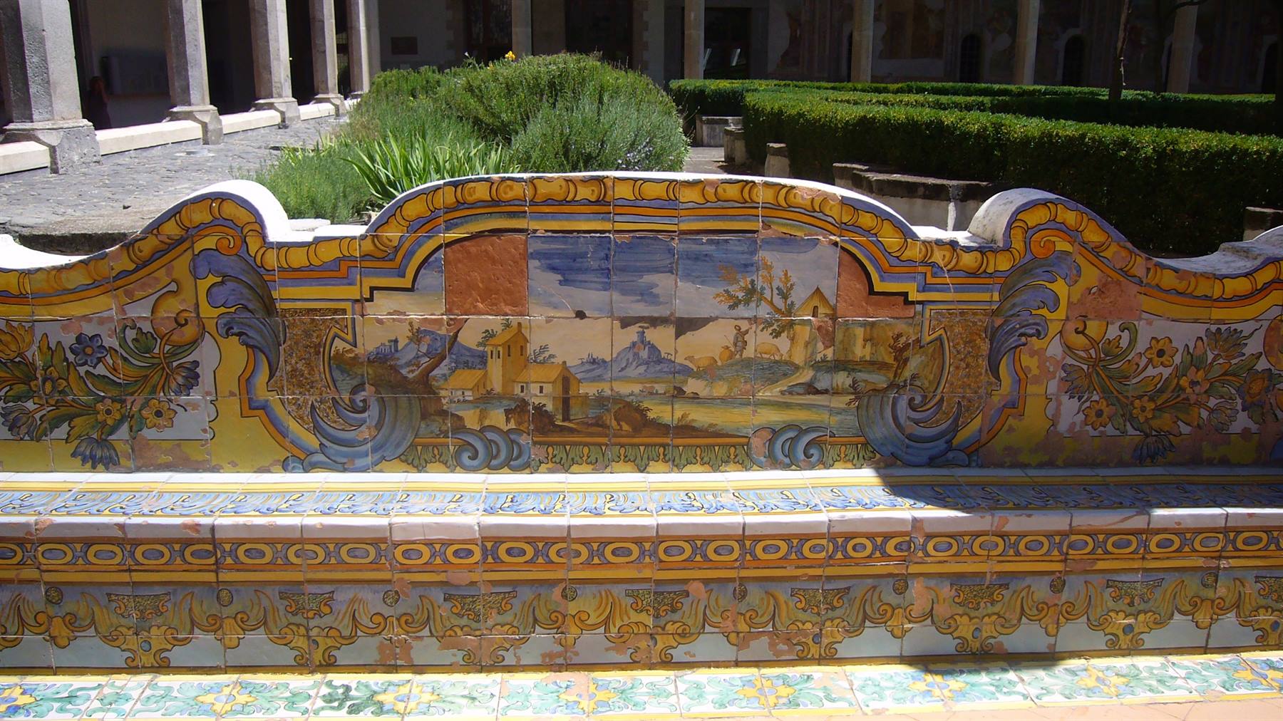 Panchina maiolicata con scene dipinte nel chiostro di Santa Chiara, sole