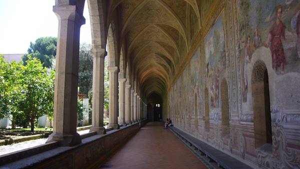 Santa Chiara cloister in Naples, frescoed arches and columns along the walkway