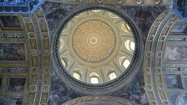 Golden coffered dome and frescoed vaults inside a baroque church