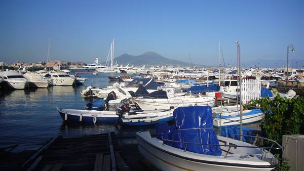 Boats moored in Naples harbor with Mount Vesuvius in the background