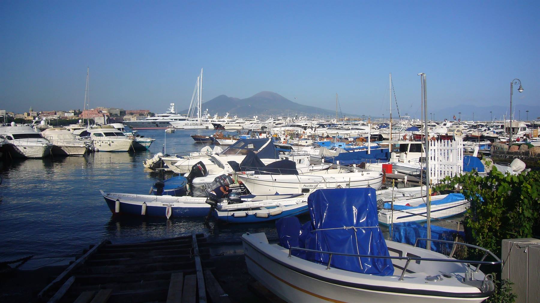 Barche ormeggiate al porto di Napoli con il Vesuvio sullo sfondo