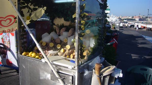Lemon and drinks kiosk on Naples waterfront, bright sunlight