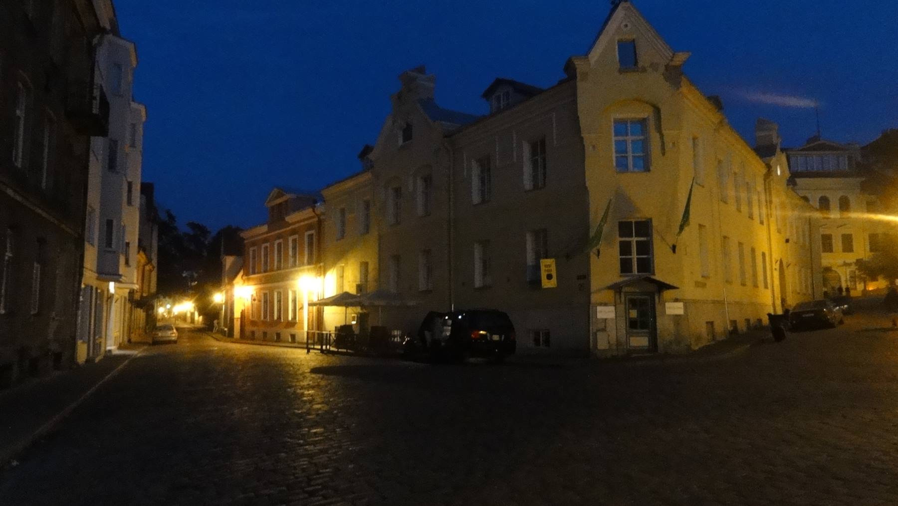 Piazza in ciottoli con edifici storici illuminati da lade notturne