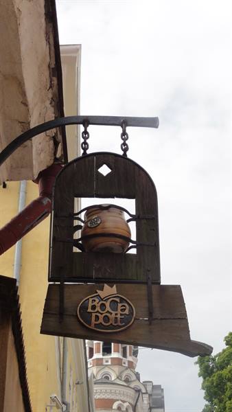 Wooden sign with ceramic pot hanging from iron chains