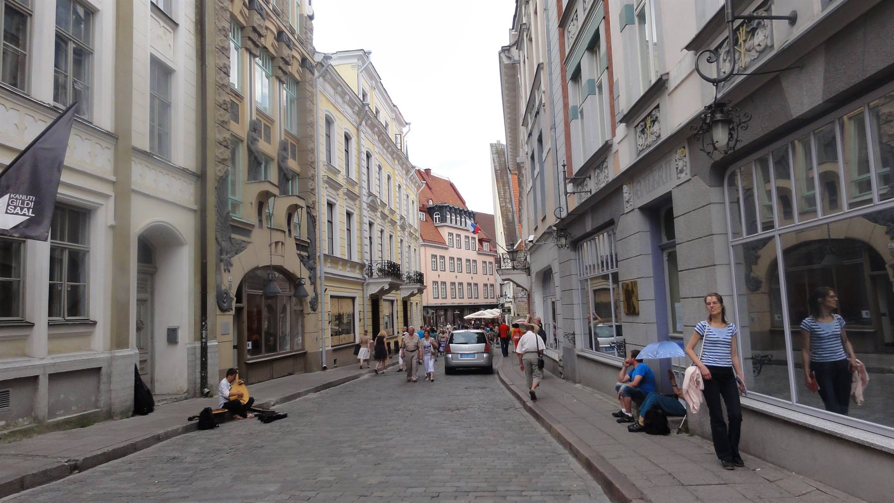 Via lastricata con facciate antiche e passanti, Tallinn
