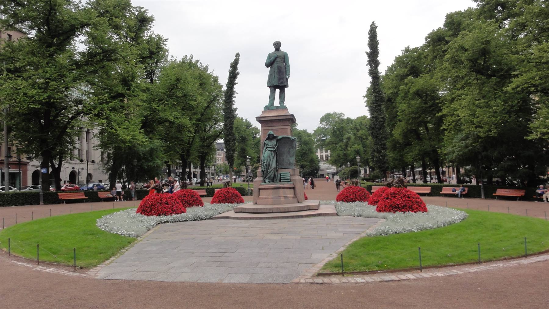 Statua di Runeberg all'Esplanadi di Helsinki tra aiuole di fiori rossi
