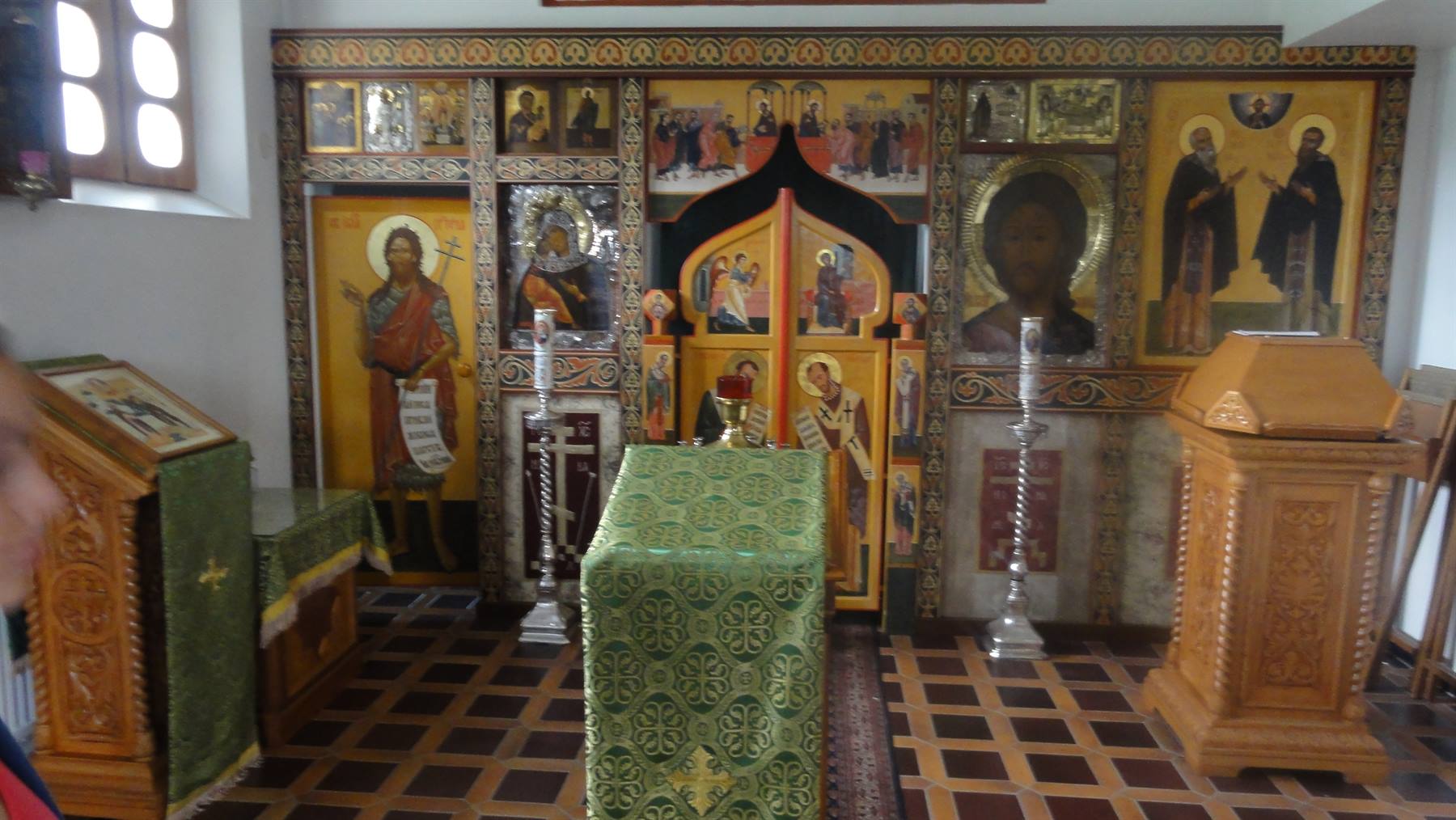 Iconostasi con icone dorate e altare coperto di verde in chiesa ortodossa