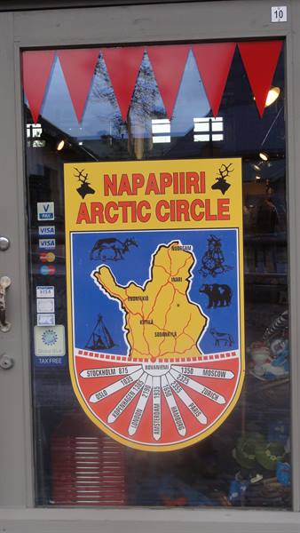 Yellow Napapiiri Arctic Circle sign on shop window with red pennant flags