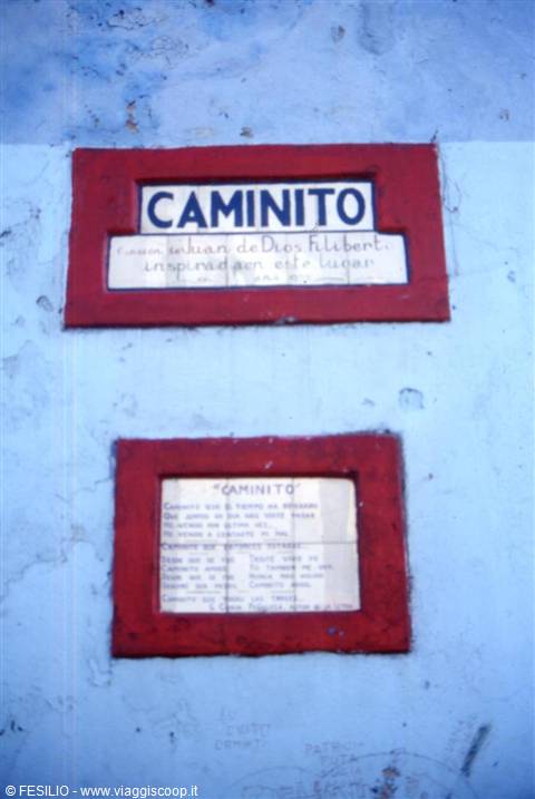 Two red plaques reading Caminito on a peeling light blue wall