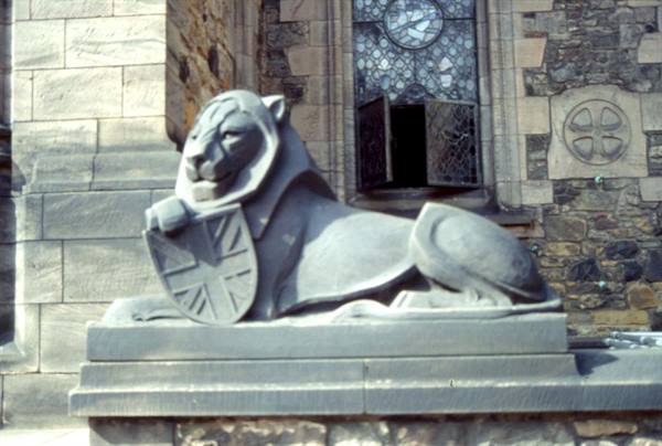 Stone lion statue with Union Jack shield outside a cathedral