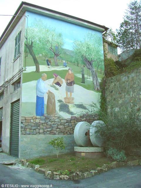 Mural of farmers harvesting olives among trees, with stone millstones below