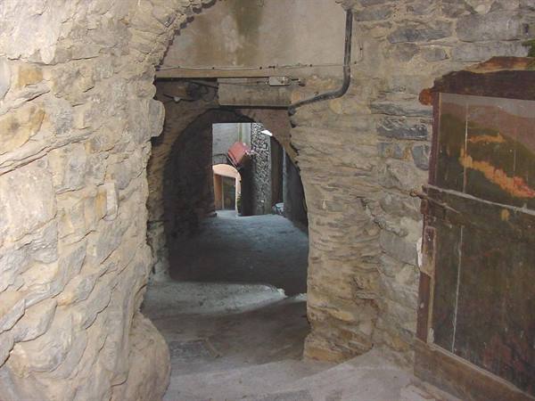 Stone archway with wooden door and steps in an old village