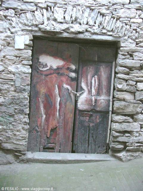 Weathered painted wooden door locked with a padlock in a stone wall