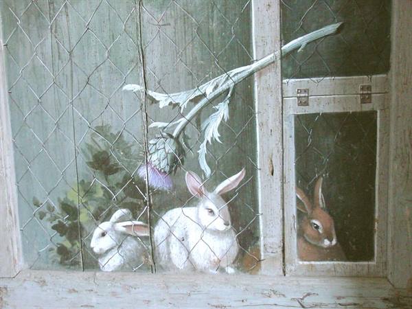 Painted rabbits on old wooden planks behind a wire mesh