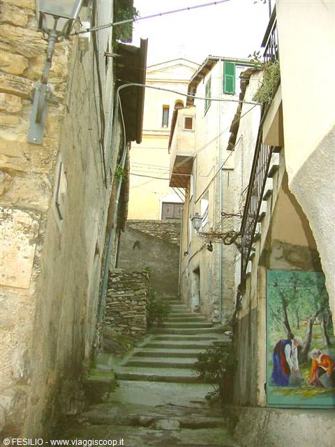 Stone staircase between old houses with a colorful mural on the wall