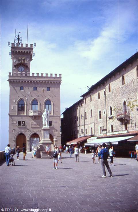 Tourists at Piazza della Libertà in San Marino, in front of the Public Palace and statue