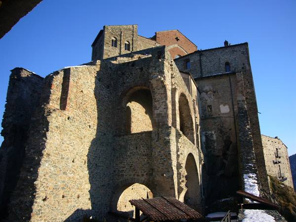 Ancient stone village walls with arches lit by sunlight