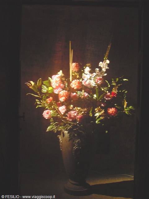 Stone vase with pink rose bouquets lit against the darkness