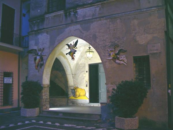 Stone arch with painted angels and illuminated nativity scene at night