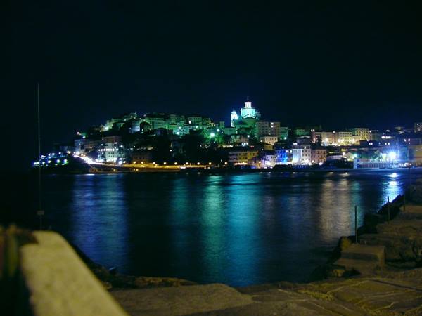 Capodimonte at night: green and blue village lights reflecting on the lake