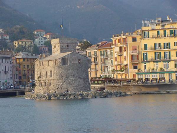 The medieval seafront castle in Rapallo, colorful buildings along the promenade