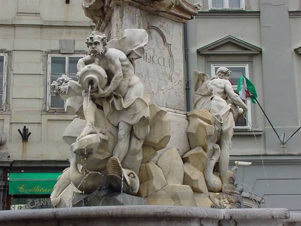 Marble statues of the baroque fountain, a man pours water from an amphora