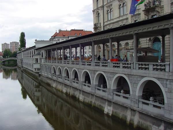 Plečnik's arcade along the Ljubljanica river, stone arches and cafés in Ljubljana