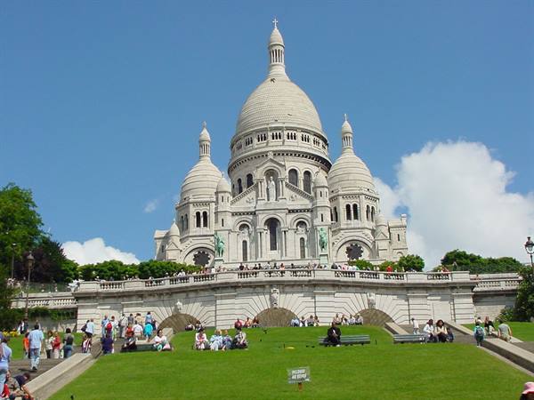 Tourists on the steps in front of the white Sacré-Cœur basilica in Montmartre
