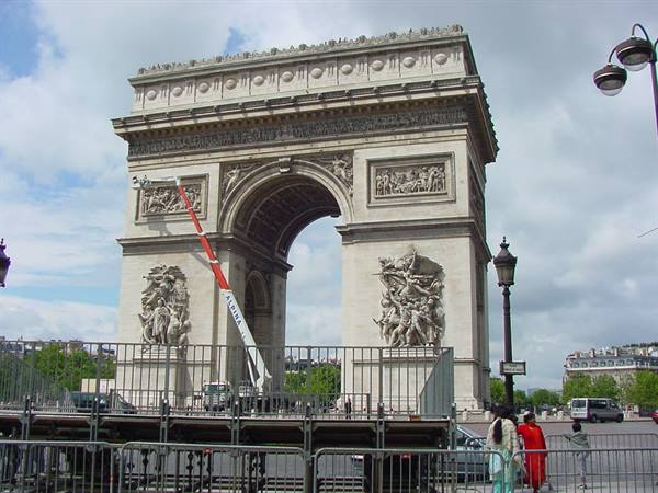 Arc de Triomphe in Paris with a worker on a lift restoring sculptures