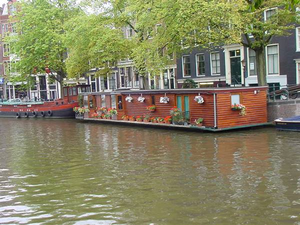Red wooden houseboat with flowers on Amsterdam canal