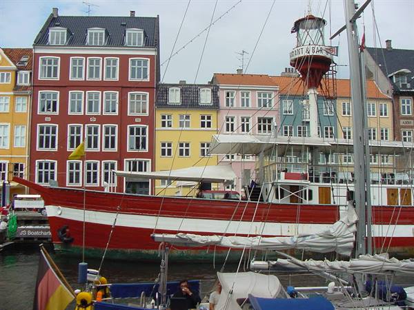 Red ship moored at Nyhavn, Copenhagen, in front of colorful townhouses