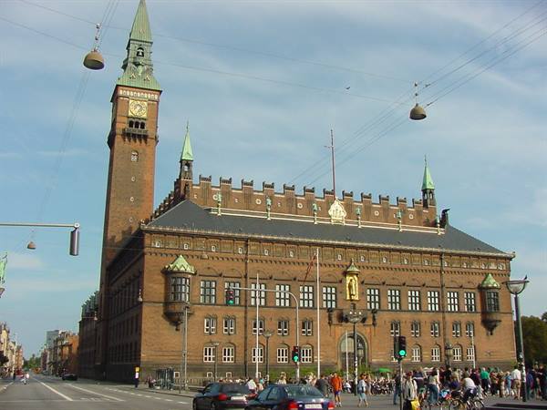 Copenhagen City Hall in morning light, red brick facade with pedestrians below