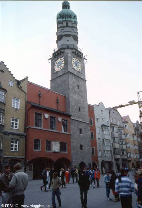 Tourists strolling beneath the clock tower of Innsbruck