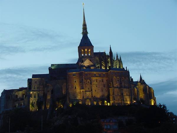 Mont Saint-Michel at dusk: the illuminated abbey rises above the rock
