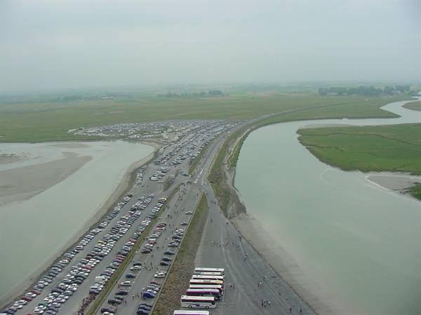 Crowded parking on the Mont-Saint-Michel causeway between sands and channels