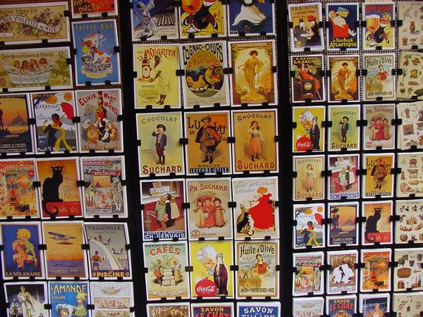 Vintage postcards with old Suchard and Coca-Cola advertisements on display