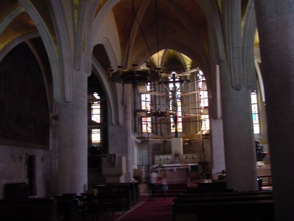 Church interior with altar, crucifix and colorful stained glass windows