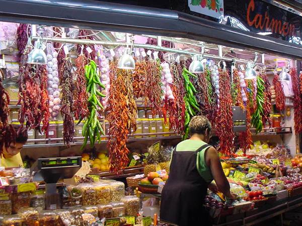 Santa Caterina market stall, hanging peppers and jars under warm lamps