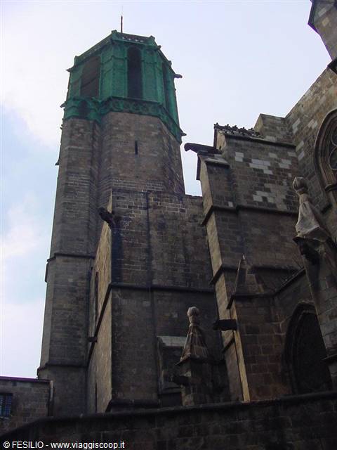 Gothic stone bell tower with green copper dome against the sky
