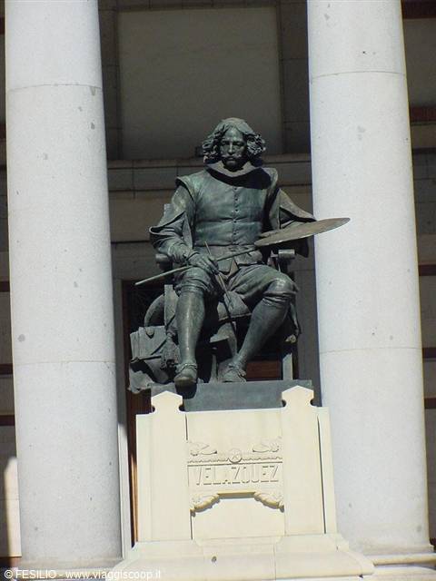 Bronze statue of Velázquez holding brush and palette between pale columns