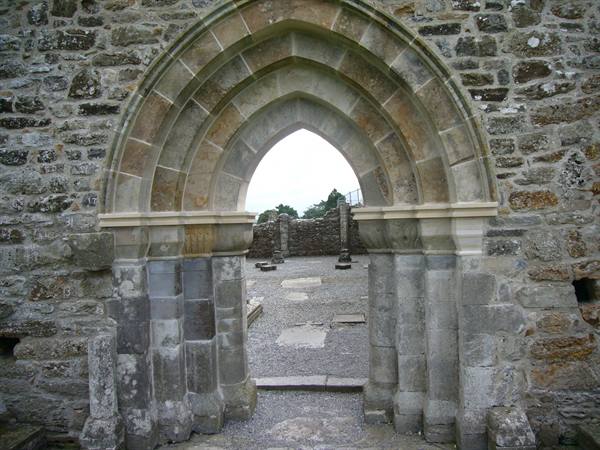 Gothic stone arch doorway of a ruined medieval abbey