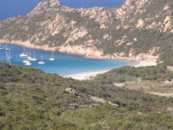 White sailboats anchored in turquoise cove among granite rocks, Roccapina