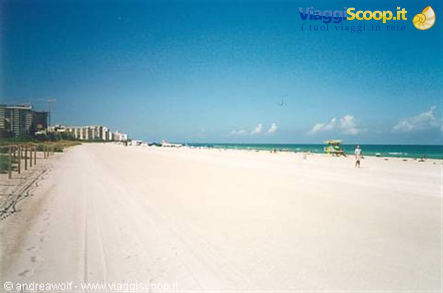 White sand beach with lifeguard tower, high-rise buildings and blue sky, Miami Beach